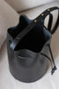 Draufsicht auf die geöffnete schwarze Bucket Bag mit großzügigem Innenraum