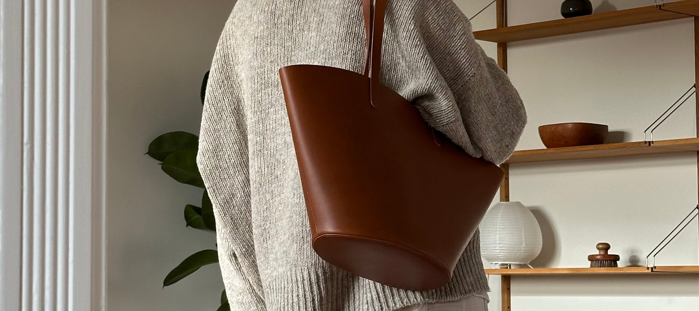 Handgefertigte Ledertasche aus pflanzlich gegerbtem Leder, getragen in einem hochwertigen Wohnambiente