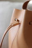Detailaufnahme des Kordelstoppers an der naturfarbenen Bucket Bag