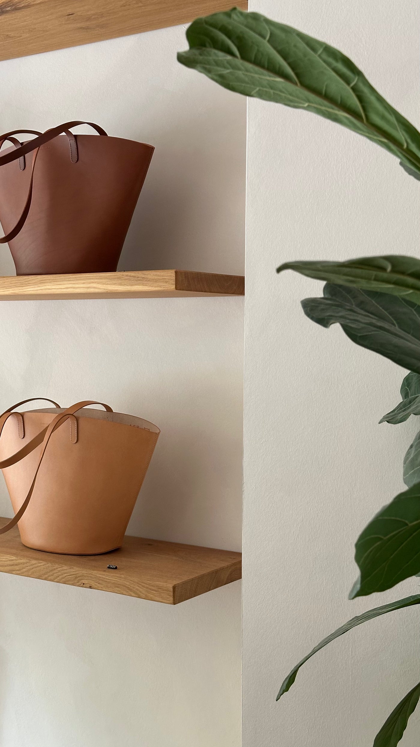 Atelier und Showroom von Sjaelv Studio in Hamburg mit handgefertigten Ledertaschen auf Eichholzregalen.